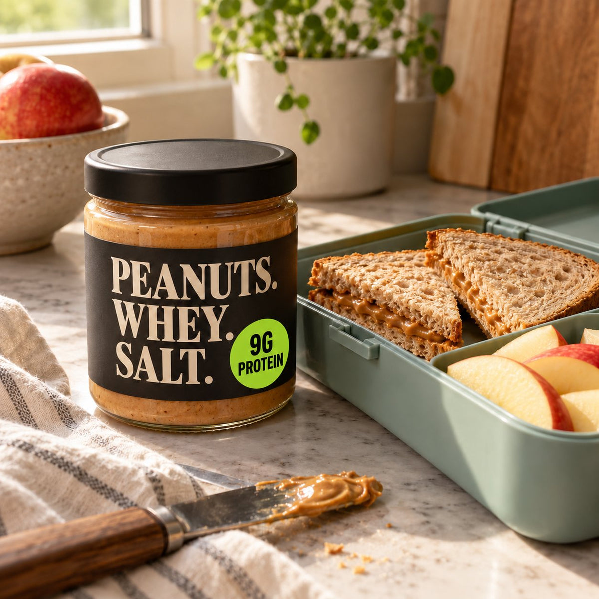 Peanut Whey jar beside a lunchbox with a peanut spread sandwich